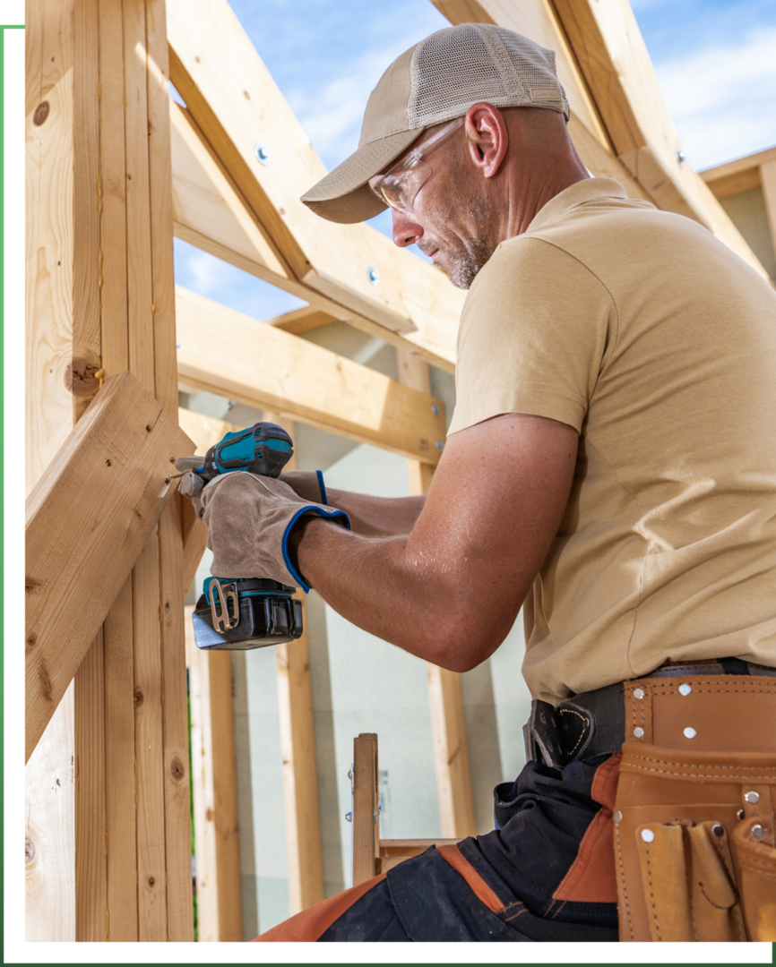 Carpenter using drill on wooden structure