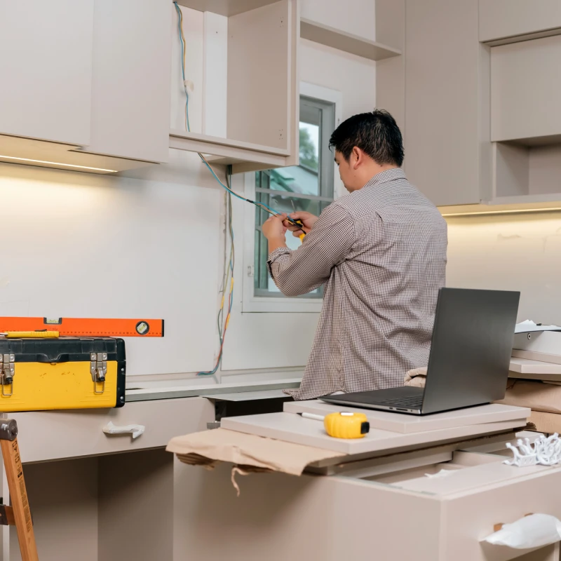 Electrician fixing kitchen cabinet wires
