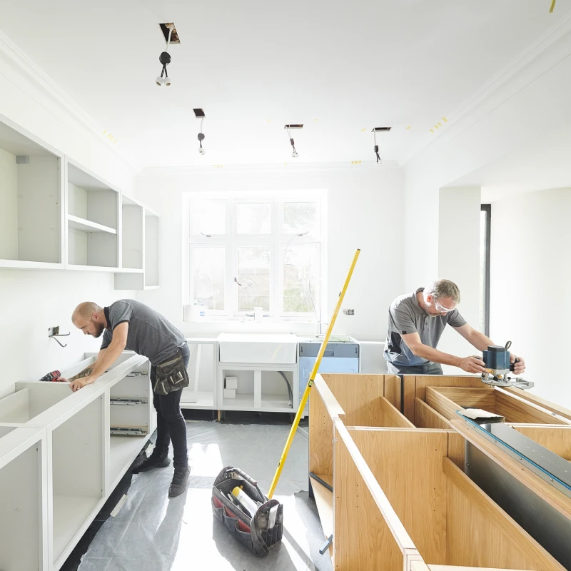 Workers installing kitchen cabinets